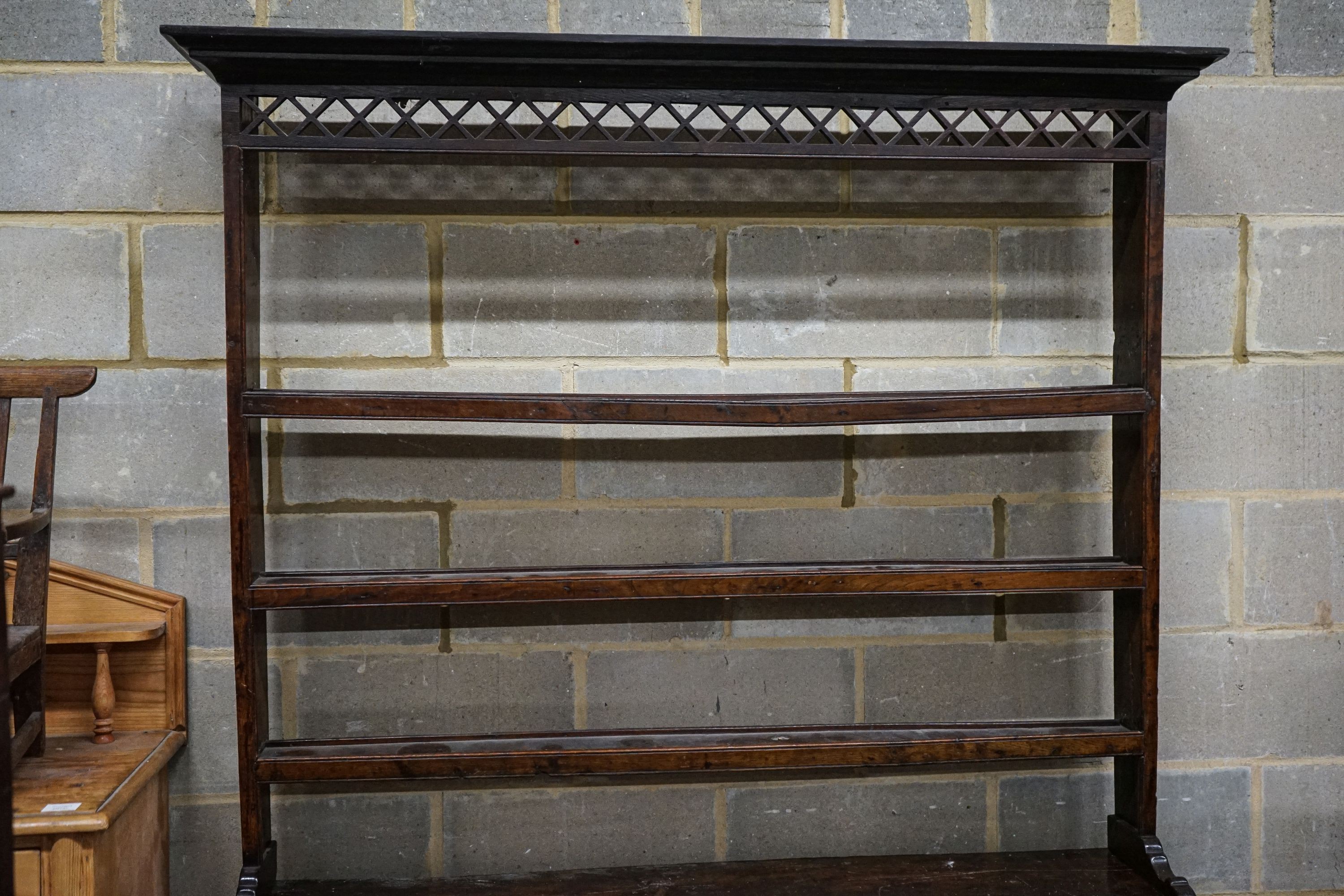 A mid 18th century oak dresser, with pierced cornice and three shelf rack over three drawers, with pierced frieze and turned and squared underframe, width 142cm, depth 46cm, height 204cm